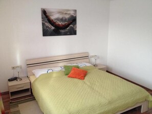 Un dormitorio con una cama, una mesita de noche, una lámpara y un cuadro en la pared.