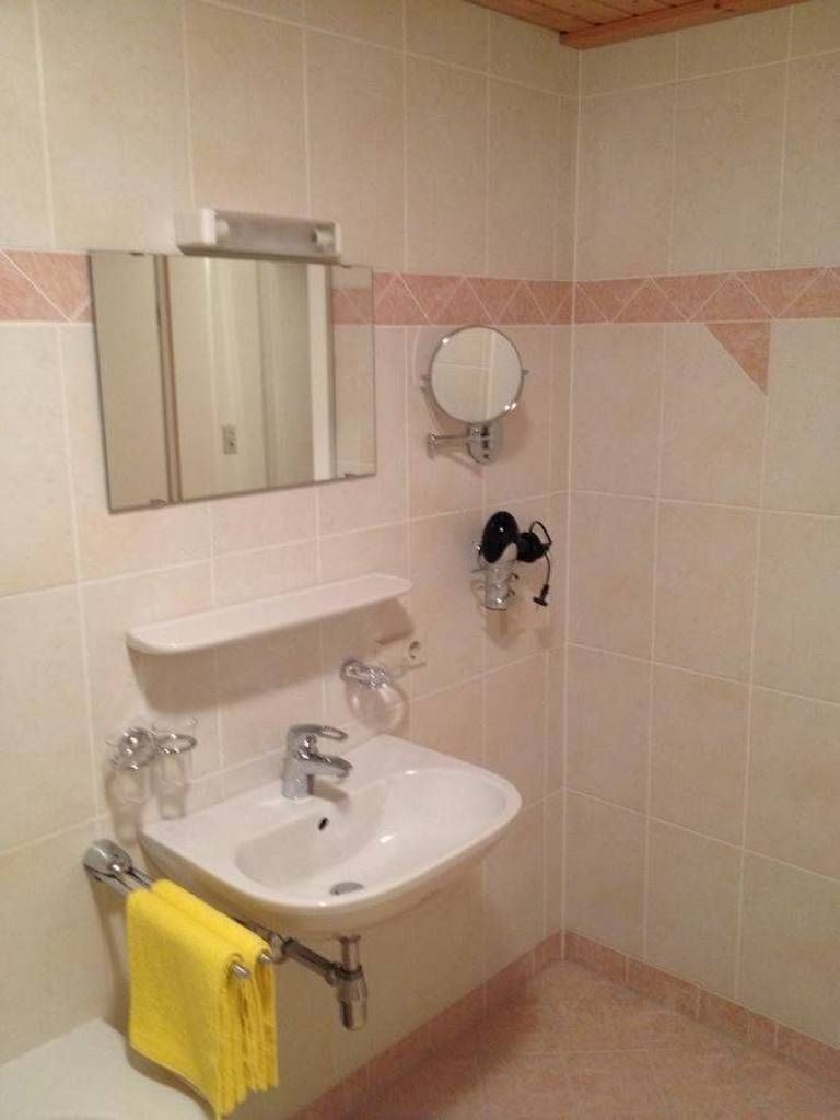 Une salle de bain équipée d’un lavabo, d’un miroir et d’un porte-serviettes.