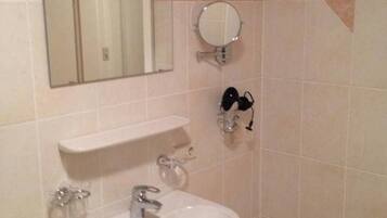 Une salle de bain équipée d’un lavabo, d’un miroir et d’un porte-serviettes.