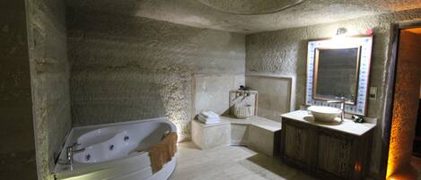 A bathroom with a freestanding bathtub, a wooden vanity, and a large mirror.