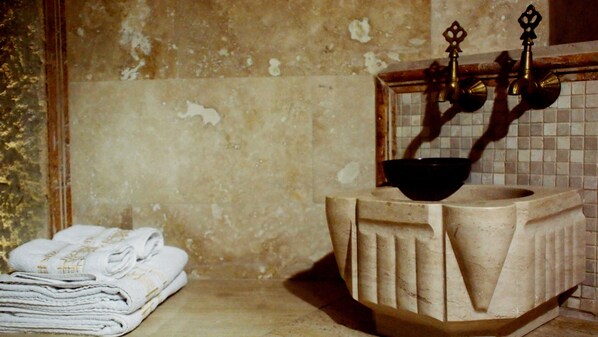 Une salle de bain avec un lavabo, un miroir et un porte-serviettes.
