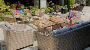 An outdoor seating area with wicker furniture and a tiled floor. - White House Hotel (Trabzon)
