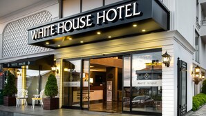 The exterior of the White House Hotel with a reception area, potted plants, and a modern facade. - White House Hotel (Trabzon)