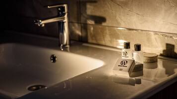 A bathroom sink with a chrome faucet, a soap dispenser, and a soap bar on the countertop.