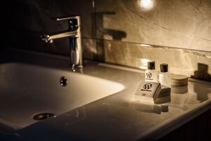 A bathroom sink with a chrome faucet, a soap dispenser, and a soap bar on the countertop.