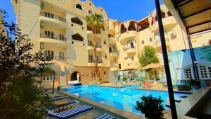 Um hotel com uma grande piscina ao ar livre, várias varandas e um pátio central.