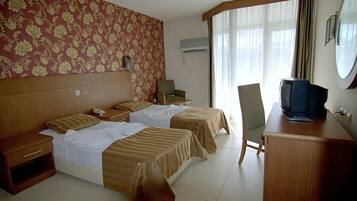 Habitación de hotel con dos camas, televisión, escritorio y una silla.