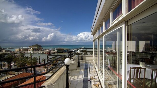 A balcony with a view of the sea and a distant island. - Surtel Hotel (Kusadasi)