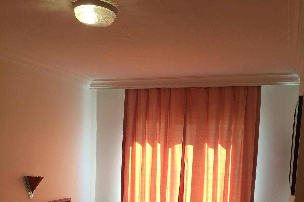 A room with two beds, a nightstand, a desk, and a chair.