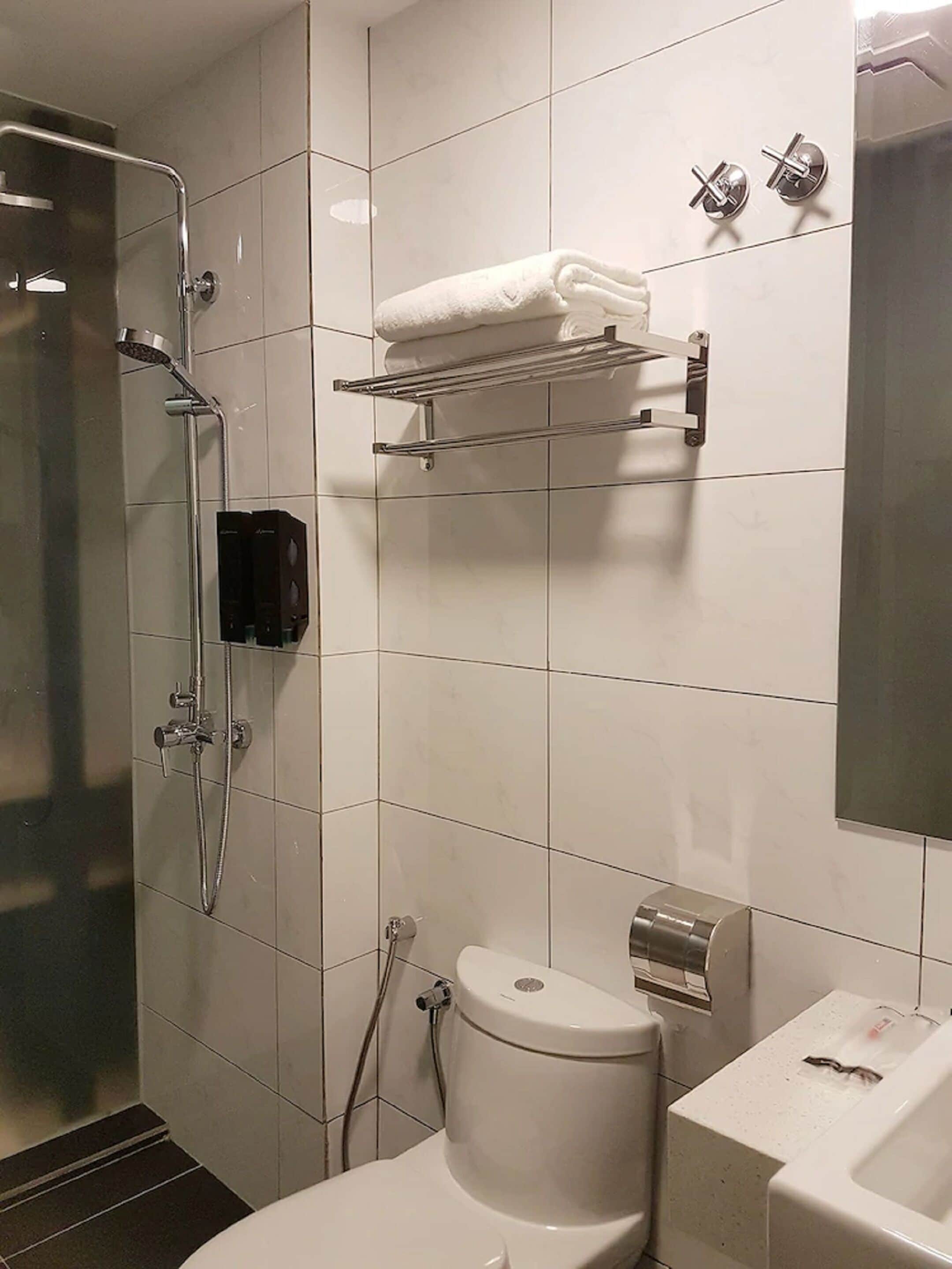 Une salle de bain moderne équipée d’une douche, de toilettes et d’un lavabo.