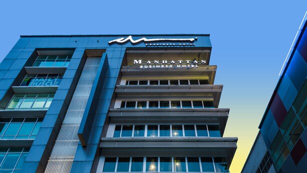 A modern hotel with a prominent sign reading "MANHATTAN BUSINESS HOTEL". - Manhattan Business Hotel TTDI (Kuala Lumpur)