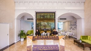 A reception area with a marble floor, a reception desk, and a green sofa. - Manhattan Business Hotel TTDI (Kuala Lumpur)