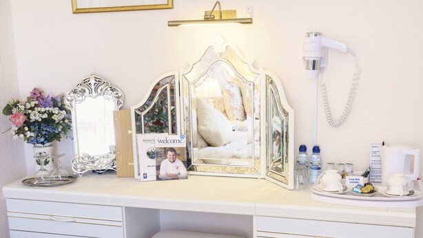 A well-organized vanity area with a mirror, vanity table, and drawers.