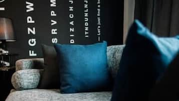 Una habitación con un sofá, almohadas y una pared con texto.