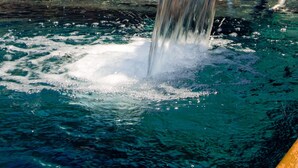 A stone wall with a water feature, including a metal bench and a metal railing. - Hotel Boutique Ses Pitreras (Sant Josep de sa Talaia)
