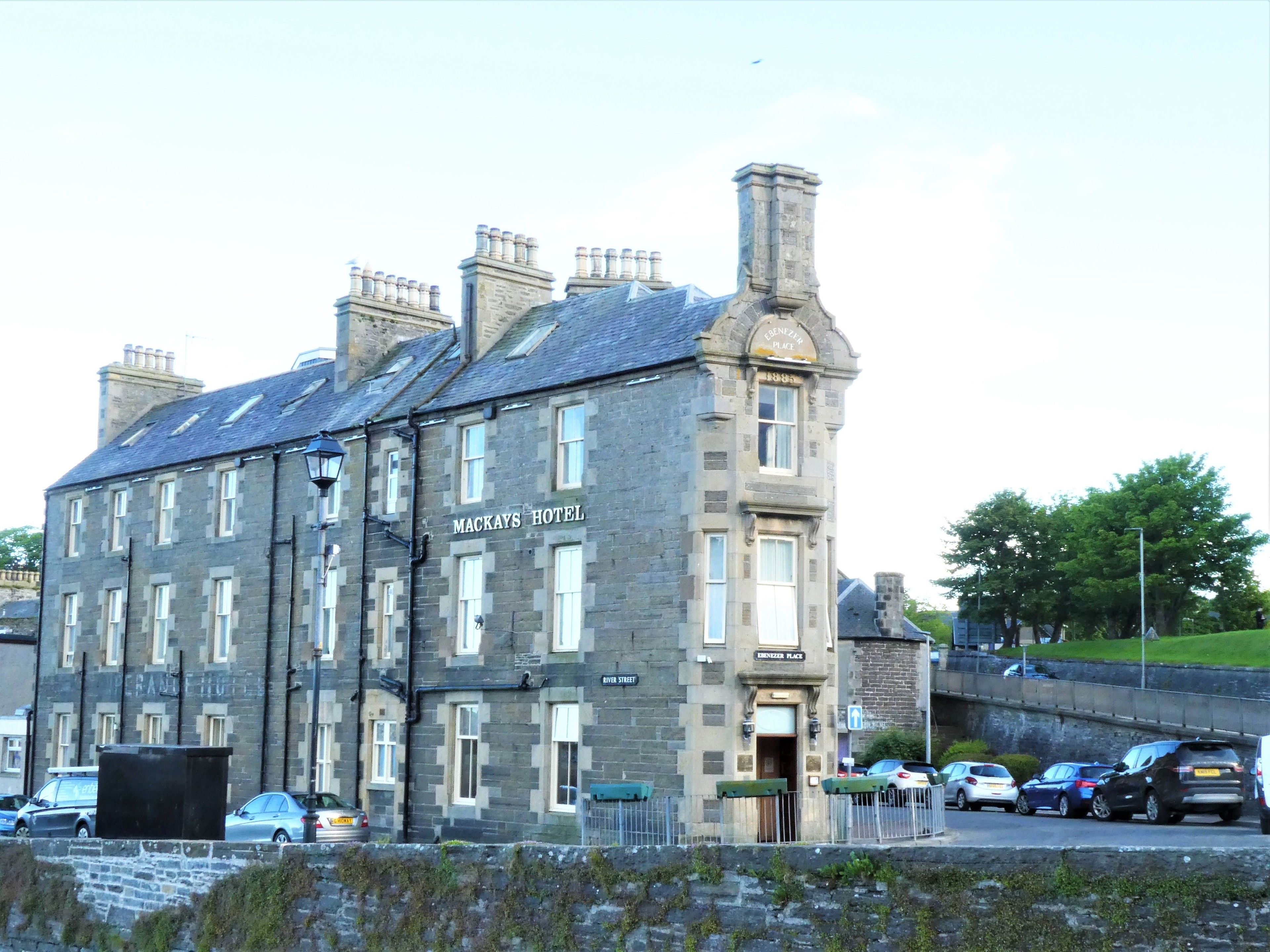 A historic building with the sign "Mackays Hotel" on the facade, featuring a traditional stone exterior and multiple chimneys.