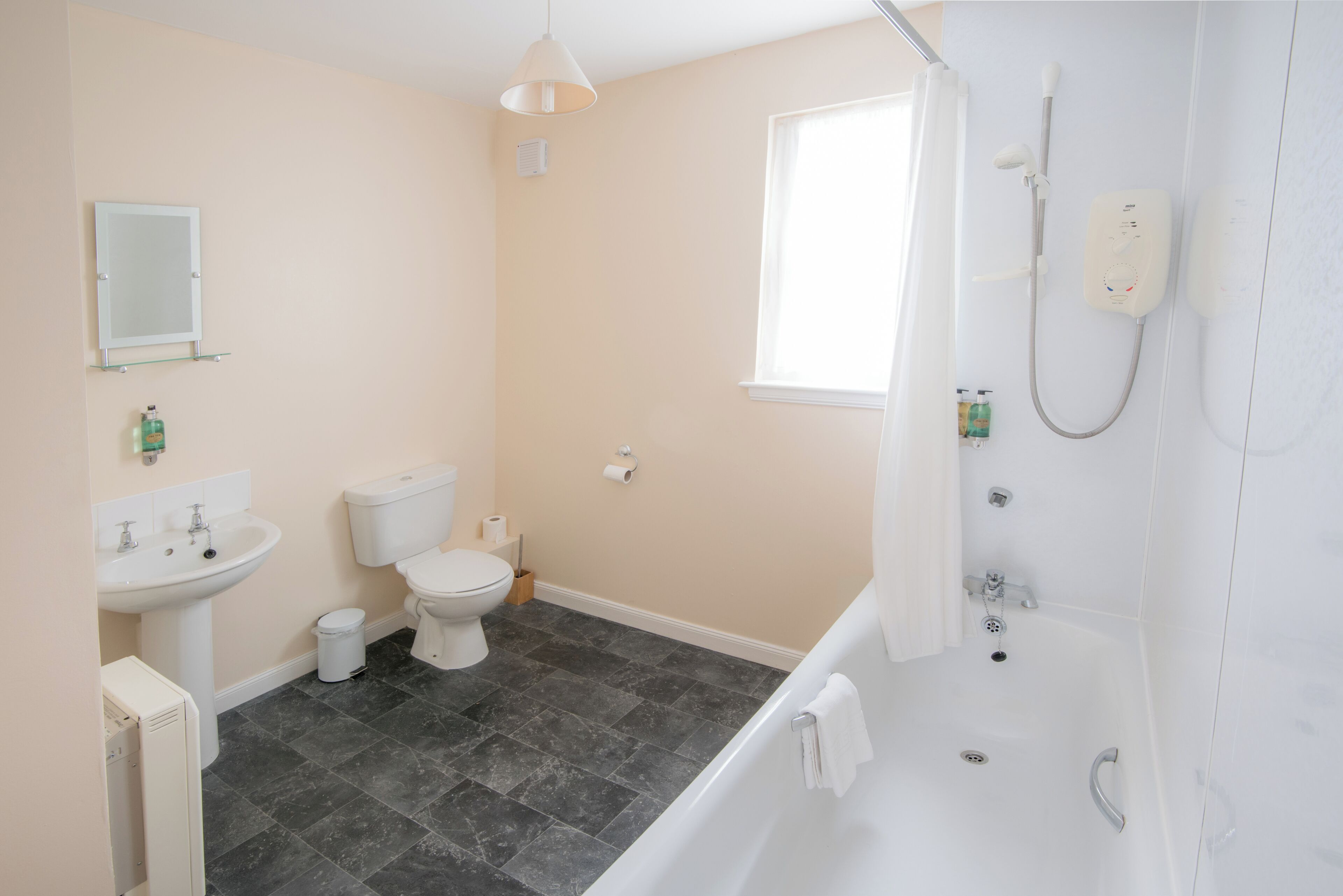 A modern bathroom with a toilet, sink, and bathtub.