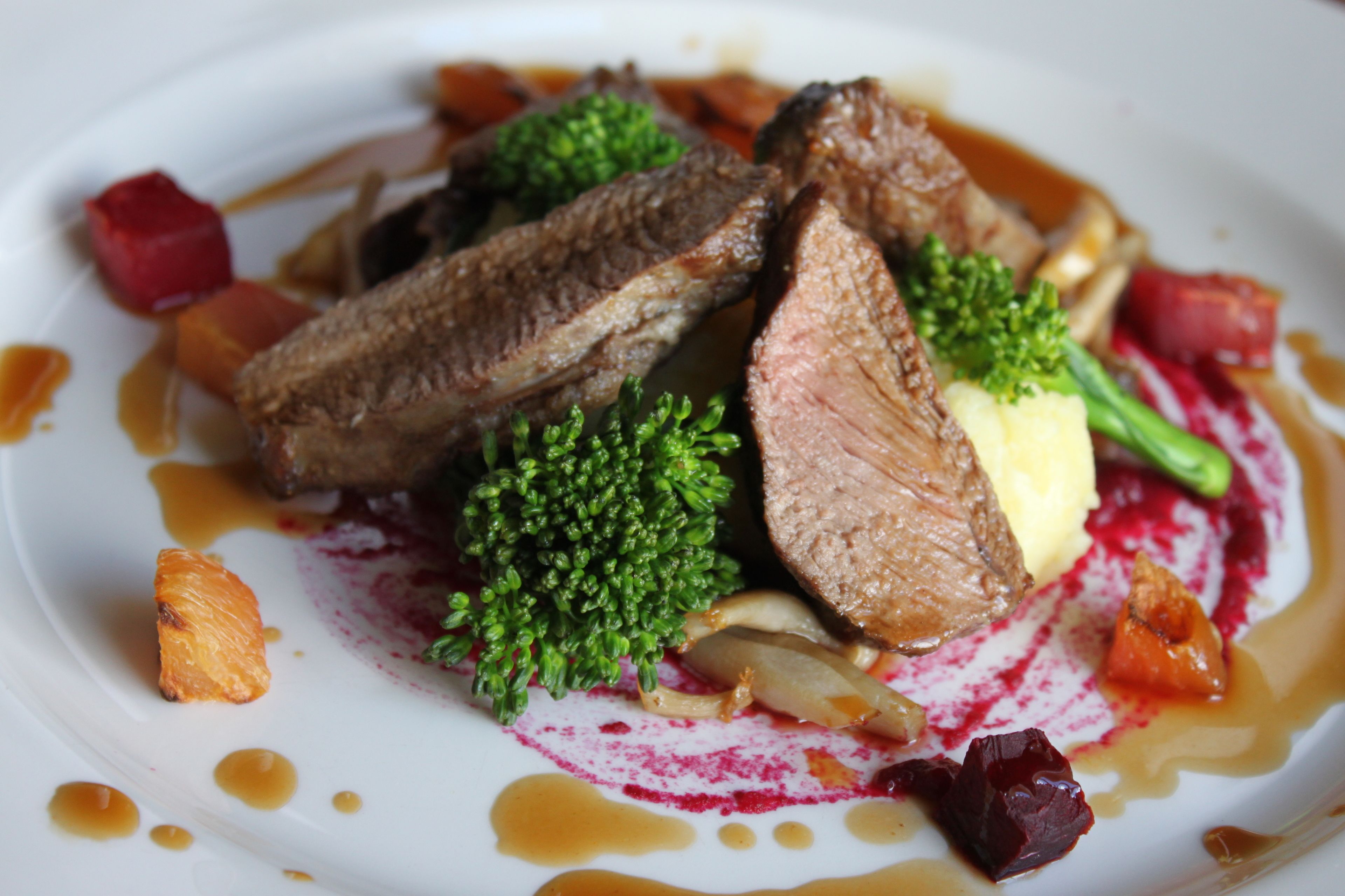 A plate of food with meat, vegetables, and sauce.