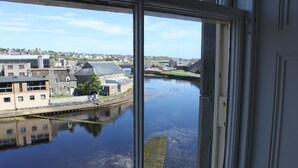 A view through a window of a river with buildings on the opposite bank. - Mackays Hotel Wick (Wick)