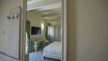 Une chambre d’hôtel équipée d’un lit, d’un bureau, d’une chaise, d’une télévision et d’un miroir.