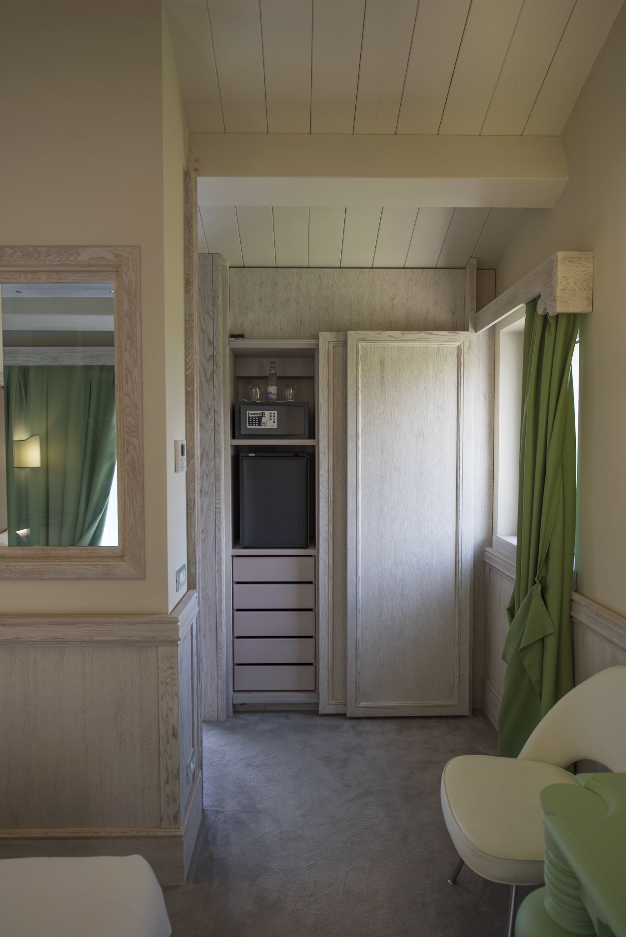 Una stanza compatta con un letto, un angolo relax, un forno a microonde e un frigorifero.