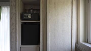 Una cocina con un microondas en la repisa superior, un refrigerador abajo y un mueble de madera a la derecha.
