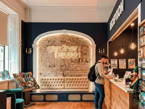 Un área de recepción con una pared de piedra, un banco y un cartel que dice 'gardiner house'.