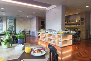 A modern dining area with a central island, seating arrangements, and a bar area with shelves of bottles.
