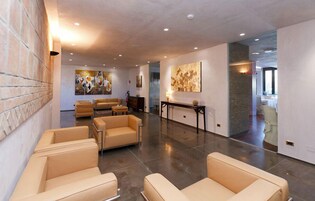 A spacious lobby with leather sofas, a fireplace, and artwork on the walls.