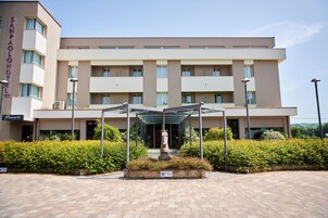 A hotel with a central courtyard, a statue, and a covered seating area.