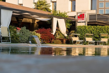 Una piscina al aire libre de temporada. Hotel Posta 77
