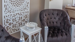 A room with two brown tufted chairs, a white table with a bowl, and a decorative white panel with intricate cut-out patterns. - Room Room Boutique Hotel (Sapanca)
