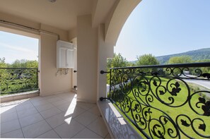 A balcony with a metal railing, a white door, and a view of a green landscape. - Room Room Boutique Hotel (Sapanca)