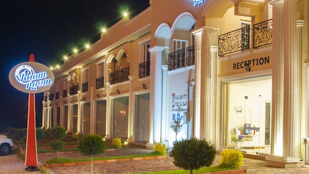 A hotel with a reception area, a neon sign, and a well-lit entrance. - Room Room Boutique Hotel (Sapanca)