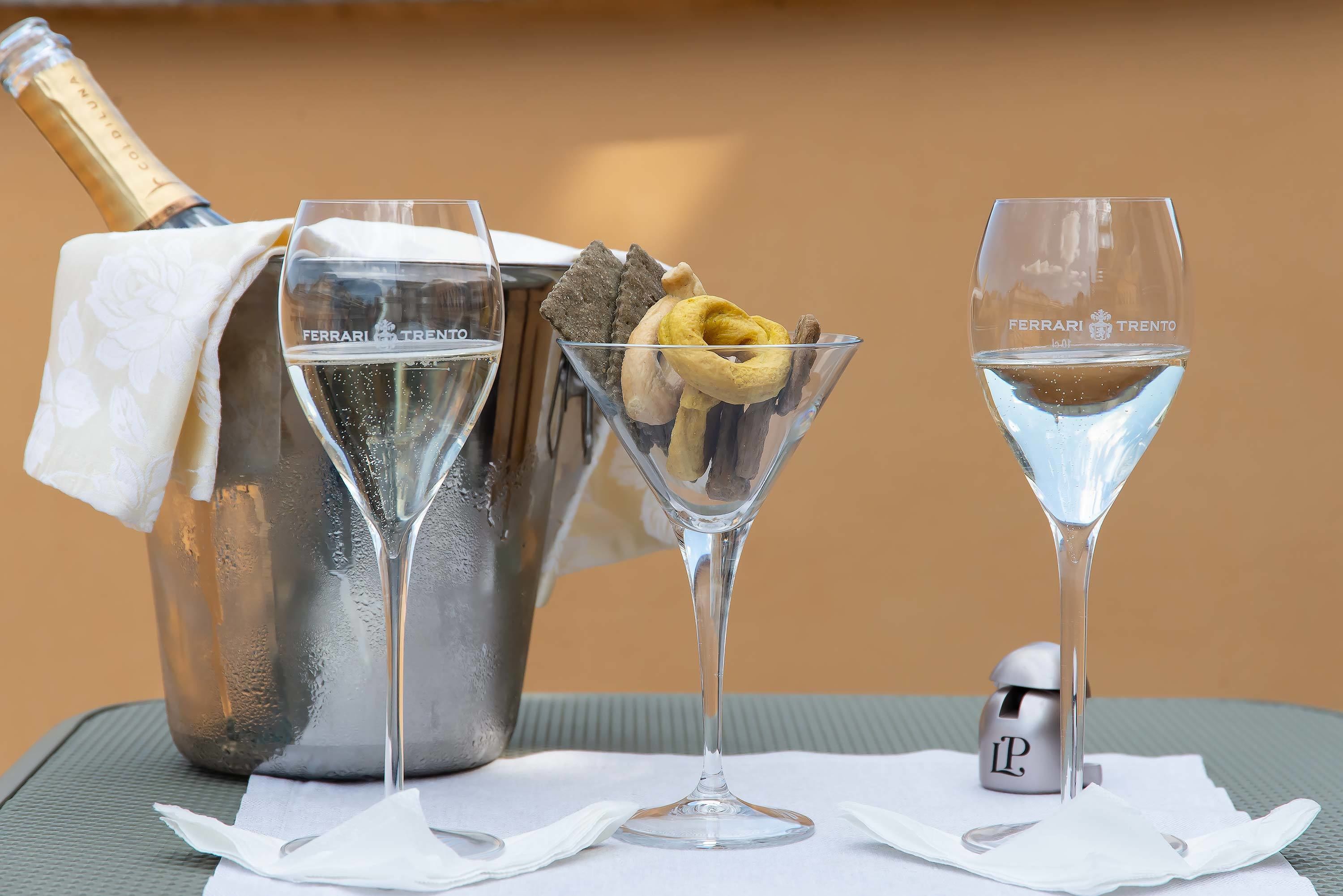 A champagne bottle, two martini glasses, and a small container with the letter "P" on a table.