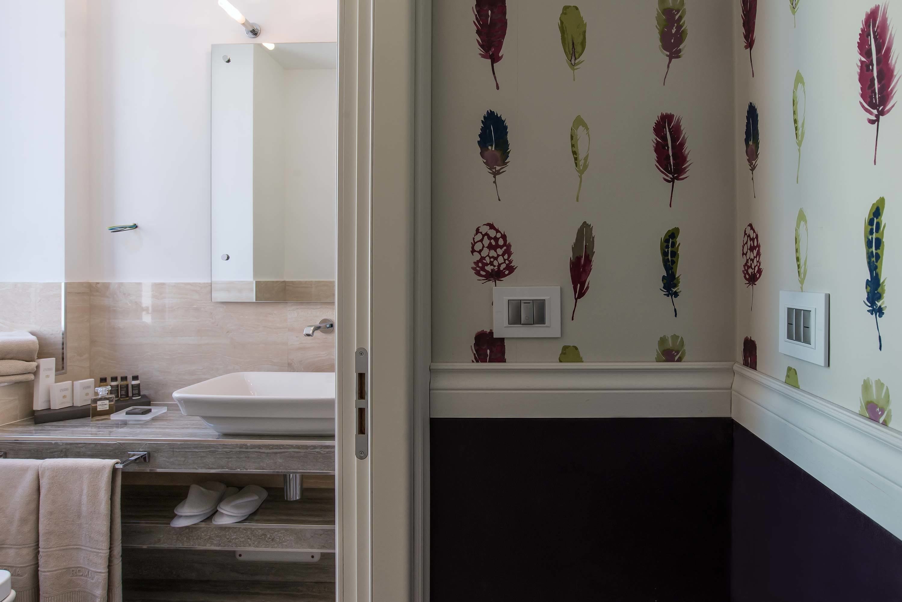 Une salle de bain avec un lavabo blanc, un miroir et un porte-serviettes.