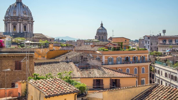 A cityscape with historic buildings, including a prominent dome structure and terracotta-tiled rooftops. - Damaso Hotel (Rome)