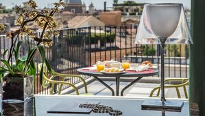 A balcony with a table set for breakfast, a potted orchid, and a lamp. - Damaso Hotel (Rome)