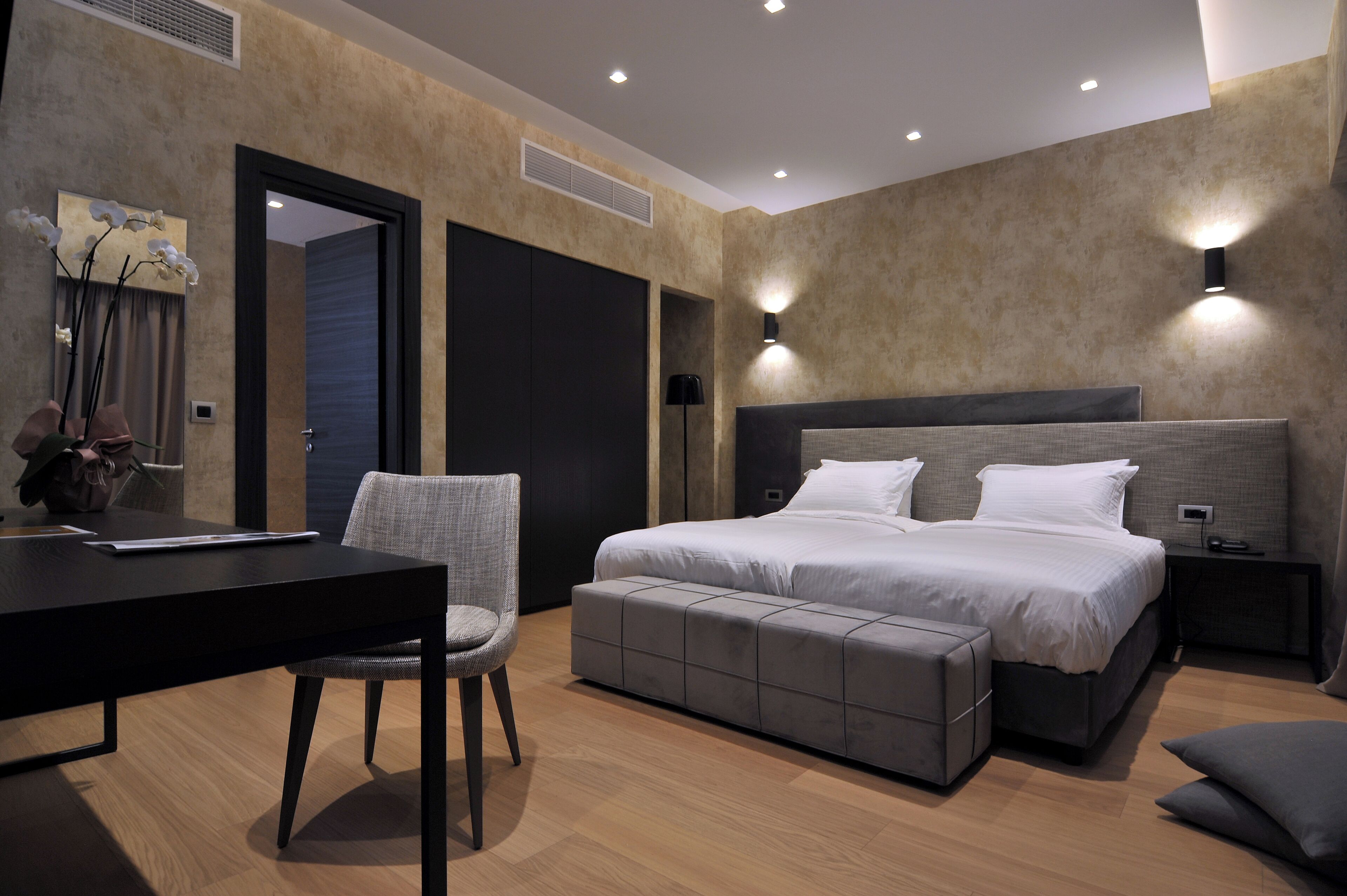 Un dormitorio moderno con una cama grande, un escritorio y una silla.