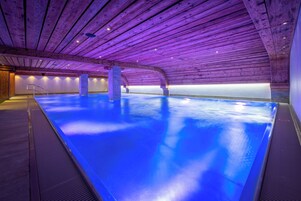 Una piscina techada, sillones reclinables de piscina