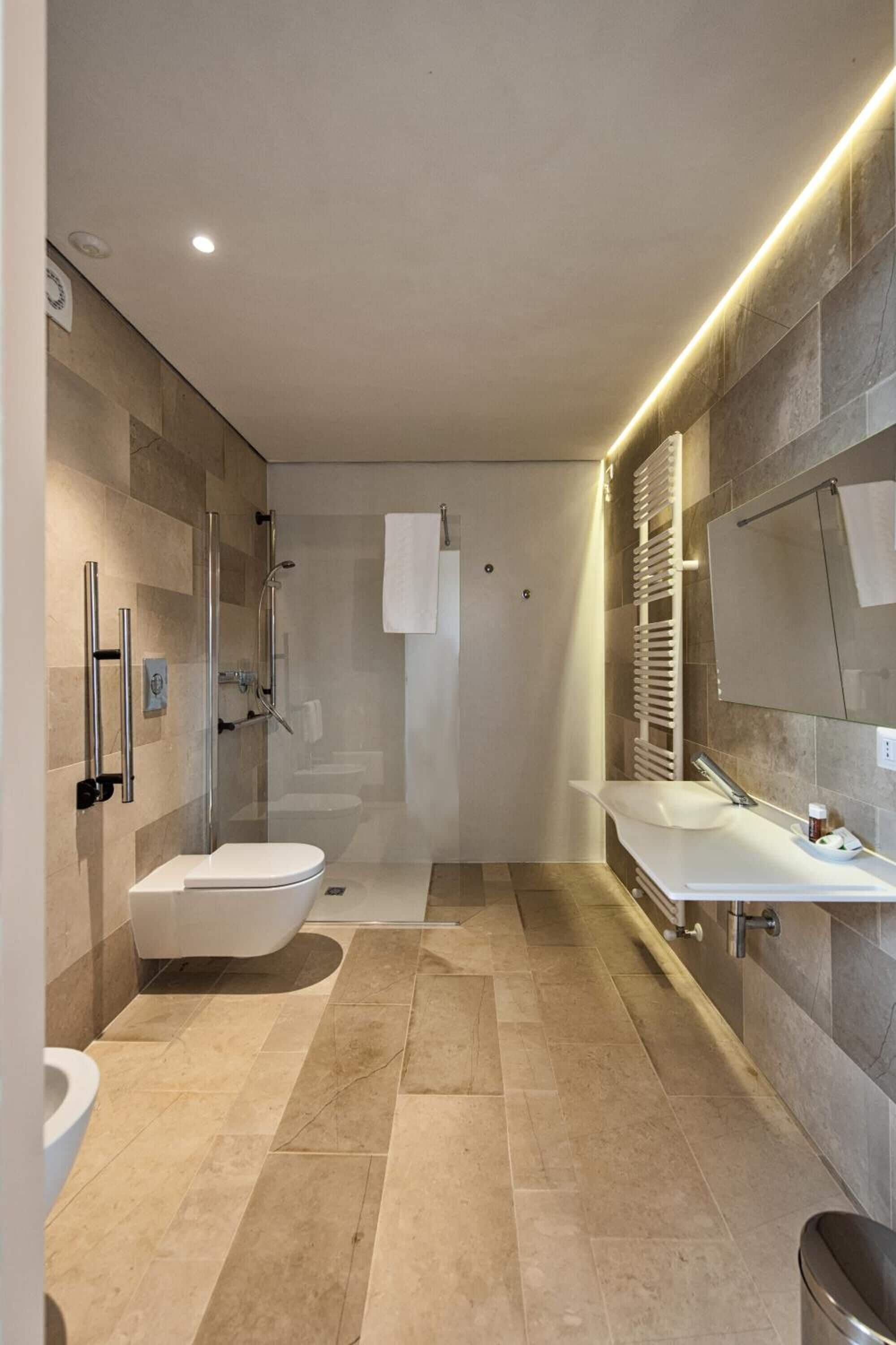 A modern bathroom with a glass-enclosed shower, a white toilet, and a vanity with a mirror.