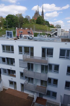 Um edifício com várias andares, varandas e janelas amplas.