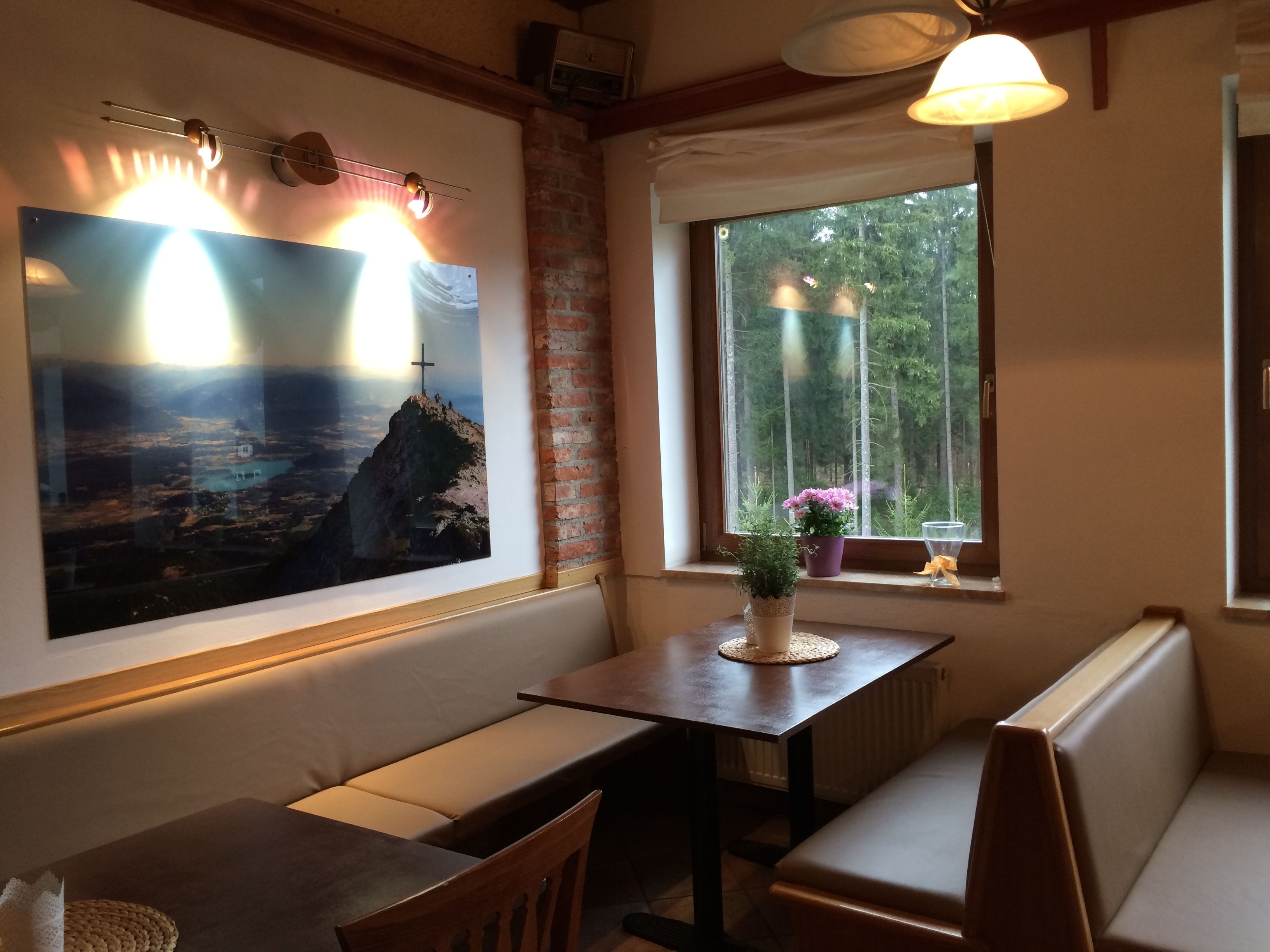 Un rincón comedor acogedor con un amplio ventanal, una mesa de madera y un banco.