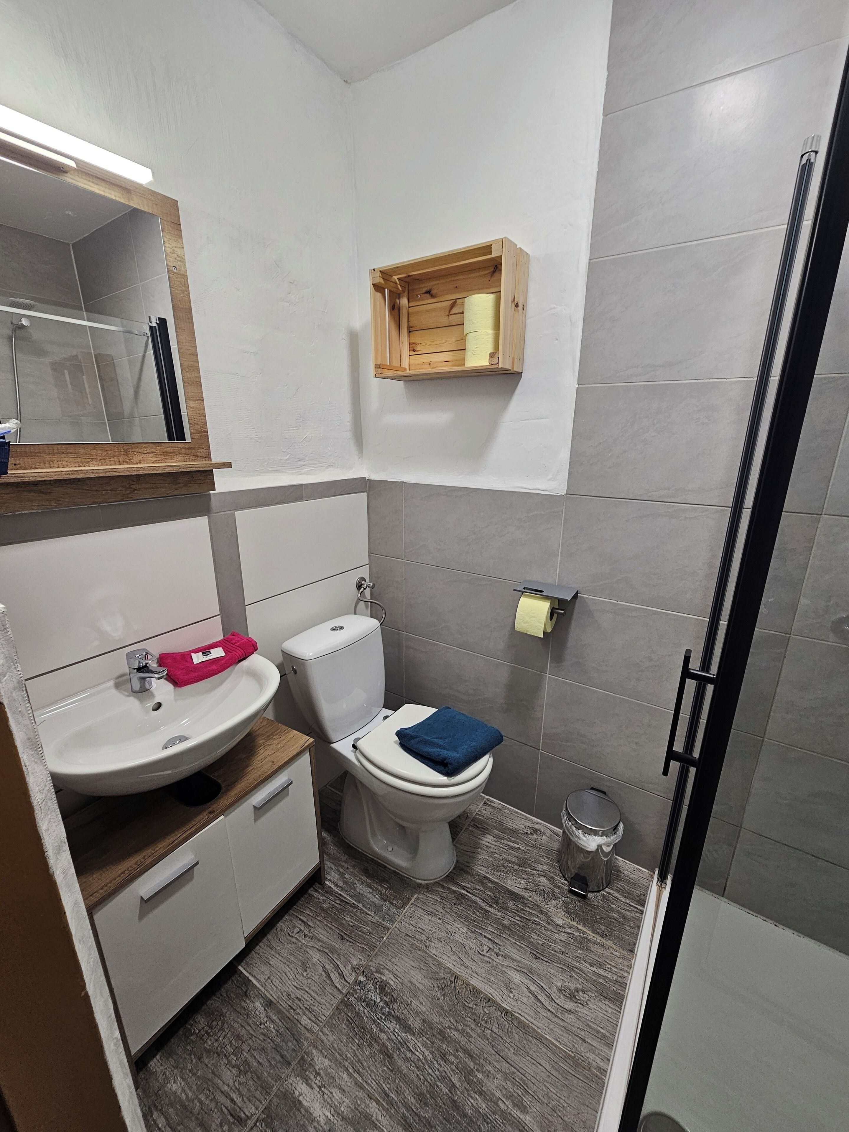 Ein Badezimmer mit einem weißen Waschbecken, einer Toilette und einem Spiegel über dem Waschbecken.