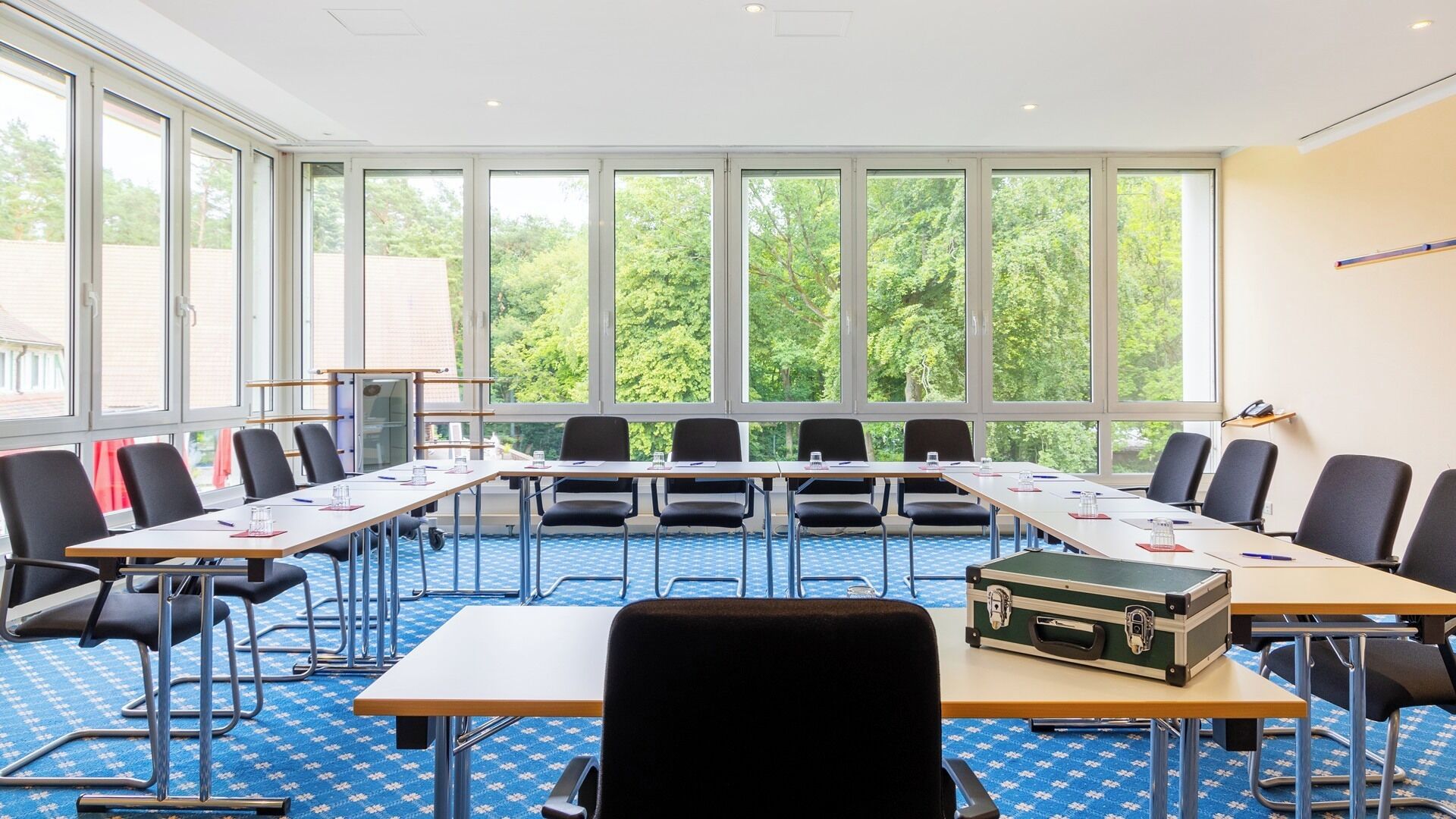 A conference room with a large table, chairs, and a projector screen.