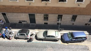 A street view with parked cars and a building with multiple windows and shutters. - Best Location in Rome (Rome)