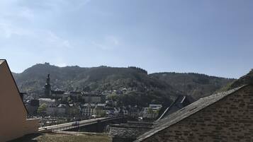 A town with a prominent hill, a bridge, and a building with a sign.