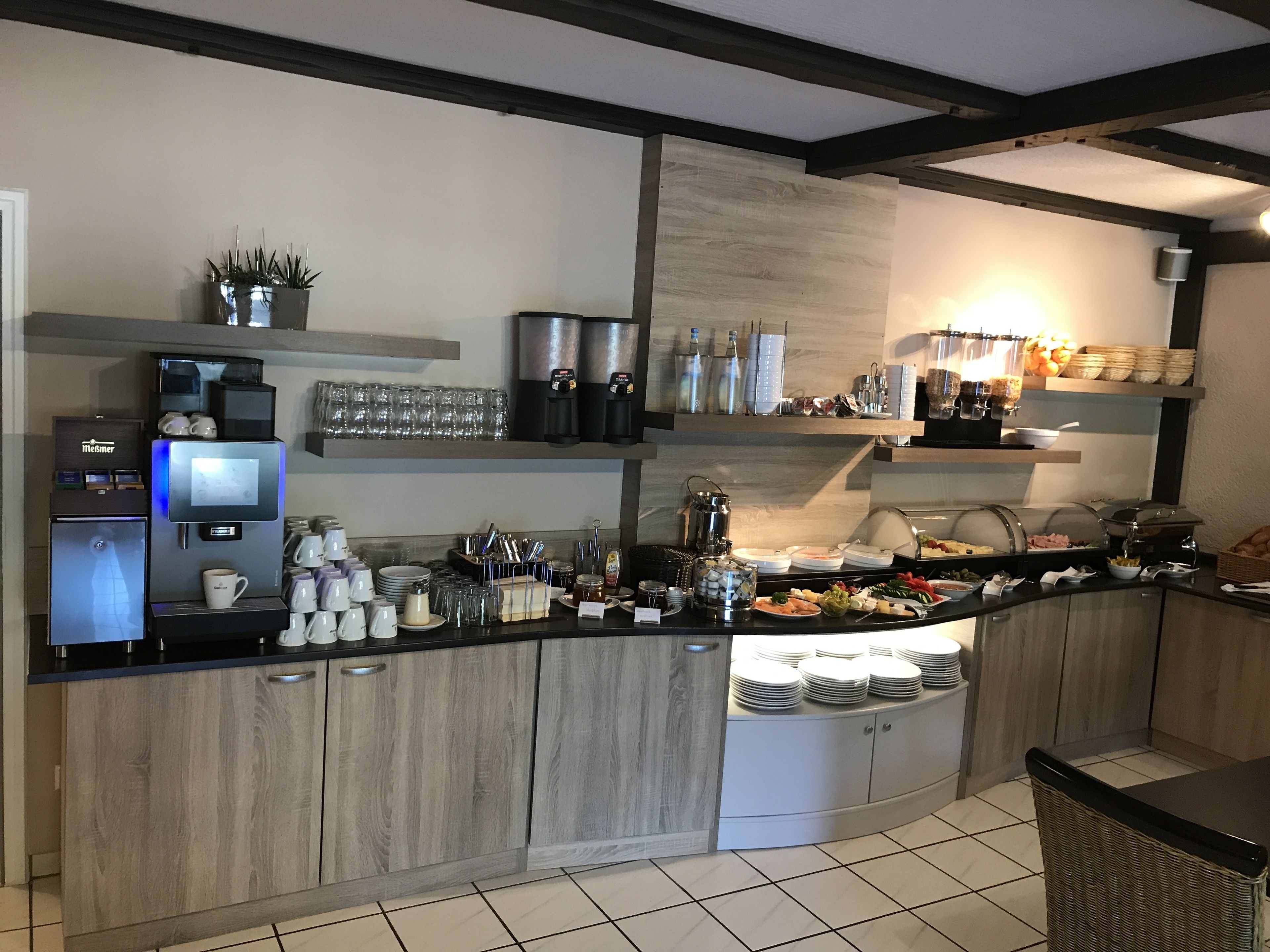 Una cuina moderna amb racó de cafè, zona de buffet i electrodomèstics integrats.
