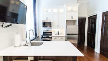 Een moderne keuken met witte kasten, roestvrijstalen apparatuur en een groot eiland.