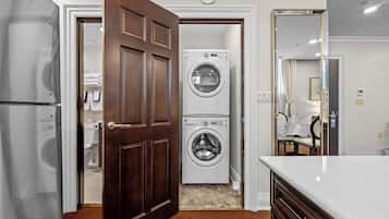 Cozinha moderna com entrada de portas duplas, eletrodomésticos de aço inoxidável e máquina de lavar e secar integradas.